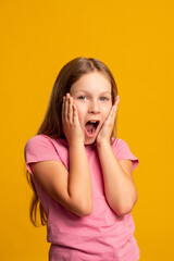 Excited kid portrait. Special offer. Wow reaction. Dream opportunity. Surprised amazed young girl with open mouth isolated on orange background.
