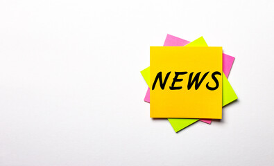 On a light background - bright multicolored stickers with the text NEWS. Copy space