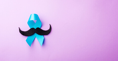 Black mustache paper and light blue ribbon, studio shot isolated on purple background, Prostate...