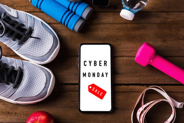 Cyber Monday sale concept with pair sports shoes, water, apple, jump rope and smartphone blank screen on wood table, Gray sneakers and accessories equipment in fitness GYM on wood table - Powered by Adobe