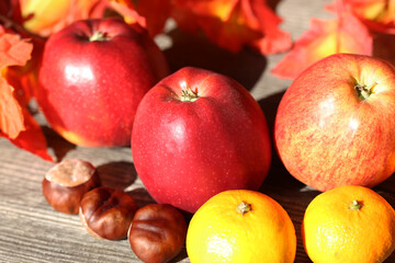 Apples and mandarins on a rustic wooden table as autumnal motif