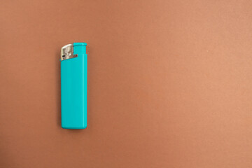 A turquoise lighter on a bright colored background with copy space. Smoking concept