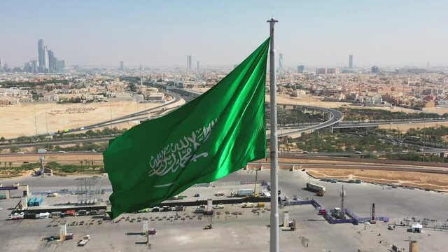 Aerial view of Riyadh with the Kingdom of Saudi Arabia flag waving on the wind / 4K #1