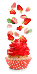 Tasty cupcake and falling strawberry on white background