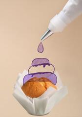 Decorating of tasty cupcake with piping bag on color background