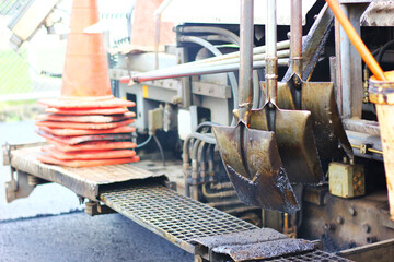 close up shovels hanging on asphalt paver machine
