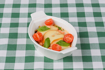 Fresh baked lasagna casserole with grated parmesan cheese, potatoes and cherry tomatoes.