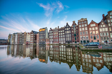 Fototapeta premium AMSTERDAM, THE NETHERLANDS - APRIL 25, 2015: Traditional houses and buildings on the canal