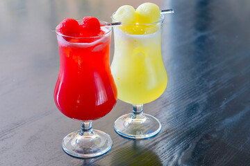Refreshing passion fruit red and yellow juice in glasses. Delicious summer cocktails.