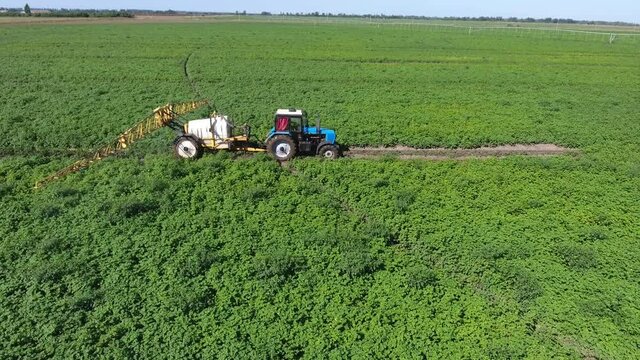 Aerial shot or a big tractor pulling a tank with water and irrigation installation