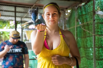 Fototapeta na wymiar cheerful girl feeds the parrots from her hands and laughs. contact zoo