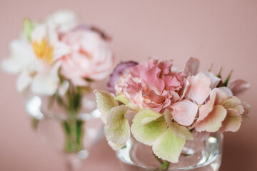 Cut flowers in glasses of water. Mini composition for table decoration.