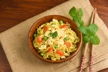 Vegetarian Schezwan Noodles Vegetable Hakka Noodles or Chow Mein in wooden bowl Schezwan Noodles is indo-chinese cuisine hot dish udon noodles Indonesian fried egg noodle. Indian Instant noodles ramen