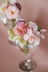 Cut flowers in glasses of water. Mini composition for table decoration.