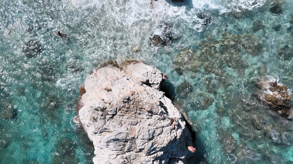 Spinning above a ocean rock, overead aerial view from drone. Vacation concept. Slow motion.