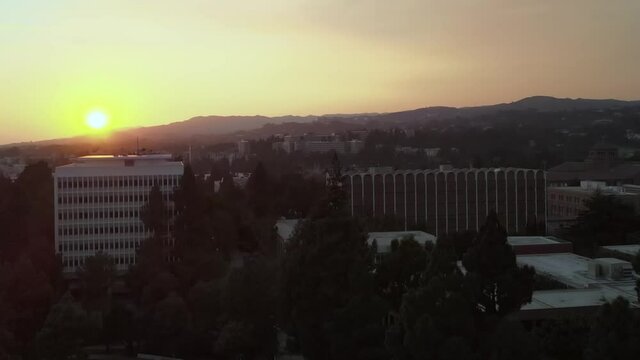 UCLA historic college campus aerial view rising over sunset horizon California landscape