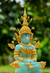 Green jade stone Buddha statue made golden cover with shape, jade stone Buddha statue with warm light.