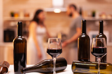 Couple in the background and glasses of wine in focus.