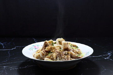 Fried and stirred cutting fresh squid with pork meat and chicken egg on the plate. Famous breakfast menu in Asia restaurant. 