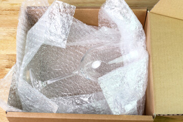 Fototapeta na wymiar the bubble wrap cover water glass in box for protection product cracked or insurance During transit
