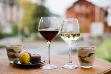Sweet dessert of tiramisu and glasses of wine outdoors on the restaurant terrace