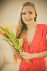 Naklejka premium Pretty woman with yellow tulips bunch