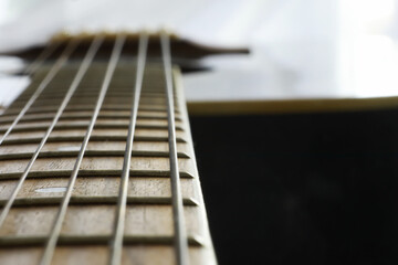 An acoustic guitar for an artist playing a stringed musical instrument on stage. Black guitar with a capo. Musical background.