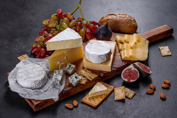 Beautiful delicious camembert cheese, parmesan, brie with grapes and figs