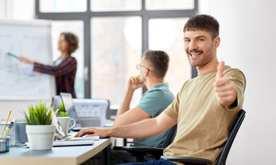 business and people concept - happy smiling man showing thumbs up at office conference