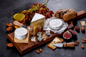 Beautiful delicious camembert cheese, parmesan, brie with grapes and figs