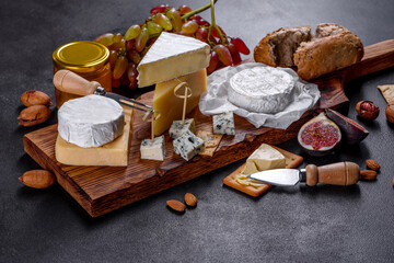 Beautiful delicious camembert cheese, parmesan, brie with grapes and figs