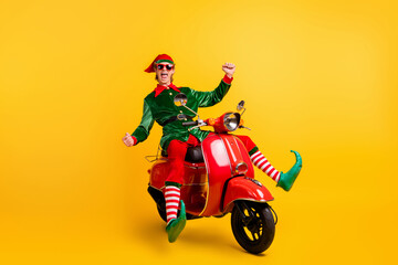 Portrait of his he nice attractive cheerful cheery ecstatic funny guy elf riding moped having fun...