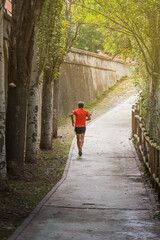 mature man making physical activity, running in the park in autumn