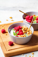 Muesli with raspberries and yoghurt in gray bowl. Healthy food concept.