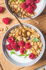 Muesli with raspberries and yoghurt in gray bowl, top view. Healthy food concept.