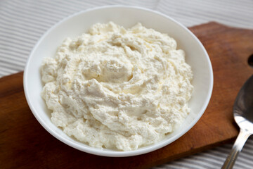 Tasty Ricotta Cheese in a White Bowl, side view. Close-up.