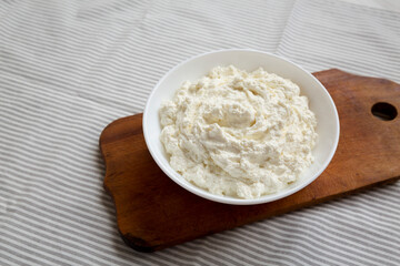 Tasty Ricotta Cheese in a White Bowl, side view. Space for text.
