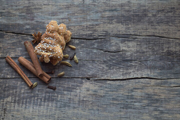 Christmas homemade gingerbread cookies with cinnamon, clove spice, sesame and anise on old wooden background with space for text.