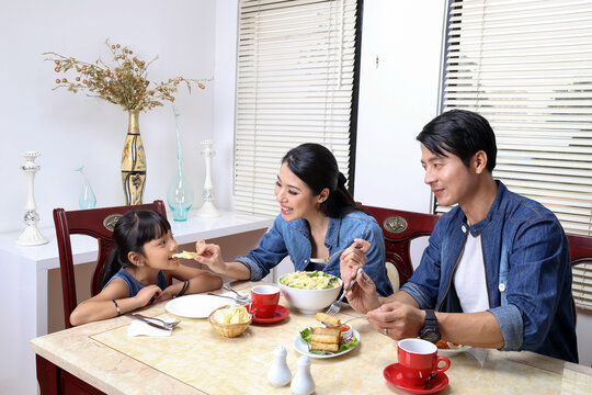 South East Asian Yong Family Daughter Child Parent Father Mother At Dining Table Eating Food Lunch