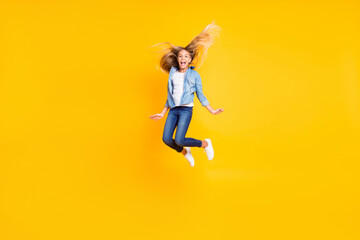 Fototapeta na wymiar Full length body size photo of happy cheerful girl with long blonde hair jumping high shouting isolated on bright yellow color background