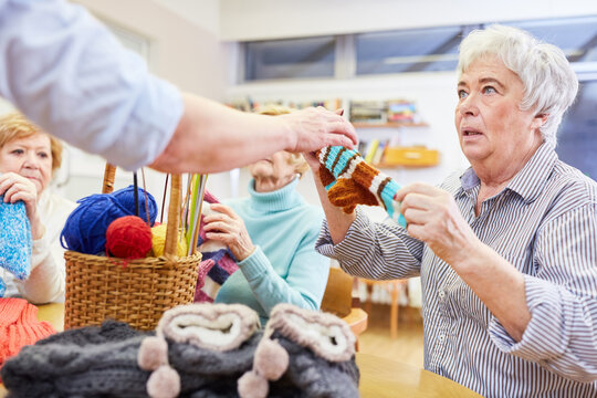 Seniorin lernt h&auml;keln oder stricken in einem Handarbeit Kurs im Altersheim