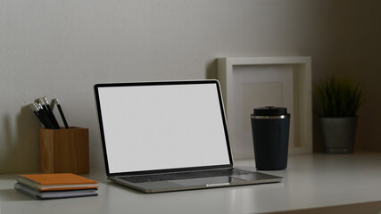 Office desk with laptop, stationery, drink-ware and decorations, include clipping path