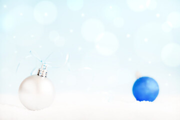 Fototapeta premium Christmas balls on surface with snow and defocused lights with copy space