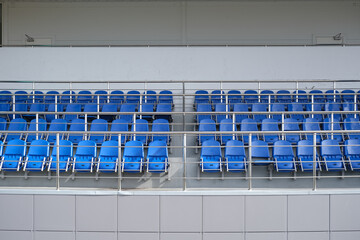 Blue chairs in the stadium. Empty tribune for spectators.