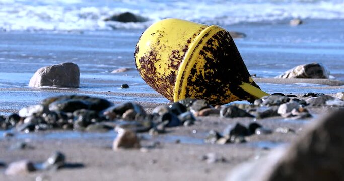 Big Yellow Buoy On Sand Beach After A Storm With The Waves Of The Mediterranean Sea In The Background - DCi 4K Resolution
