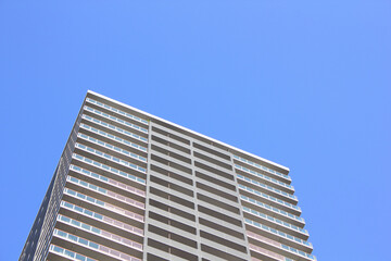 高層マンションの外壁と青空