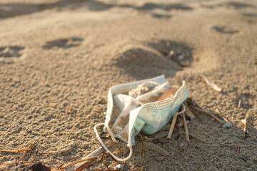 Dirty used surgical face mask discarded on sea coast ecosystem,covid19 pandemic disease pollution effects