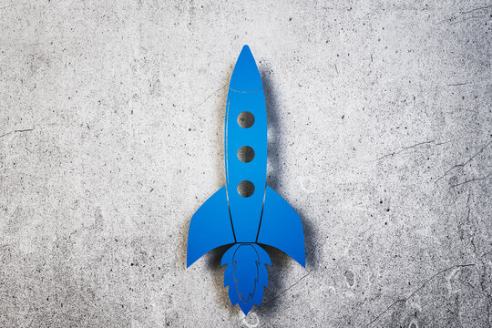 Toy Blue Rocket On Concrete Wall Background.