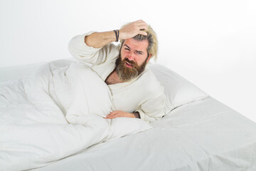 Morning and wake up. Confused bearded man in bed. Man in bed. Man sleeping in comfortable bed at...