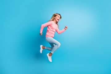 Fototapeta na wymiar Photo portrait of girl jumping up running isolated on pastel blue colored background